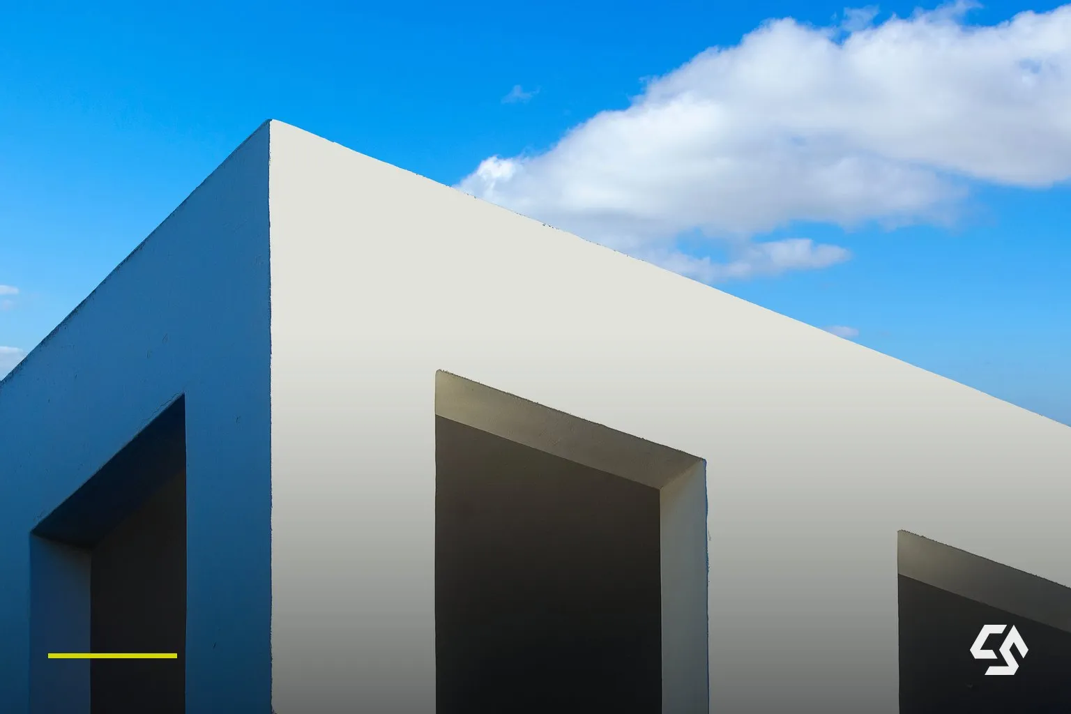Klare, geometrische Fassade einer modernen Architektur vor blauem Himmel.